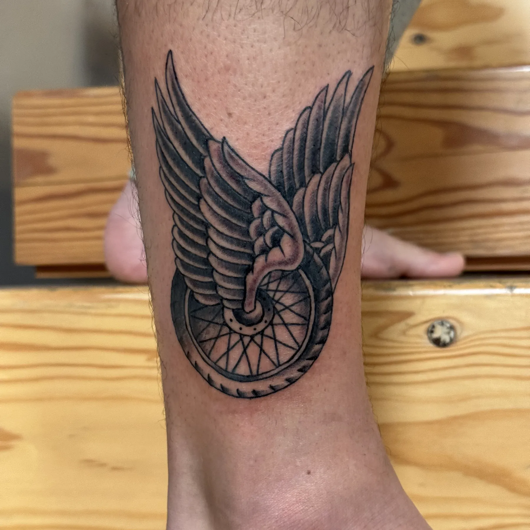Winged wheel traditional black and gray tattoo